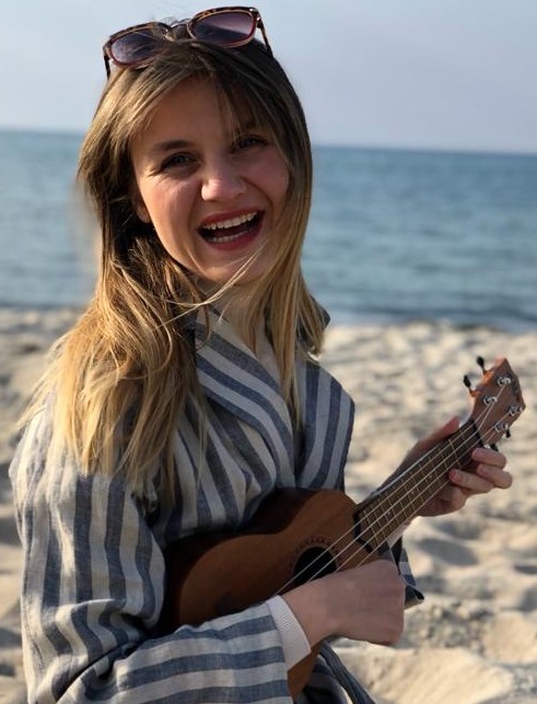 Musikschullehrerin Sandra Becker steht am Strand und spielt Ukulele